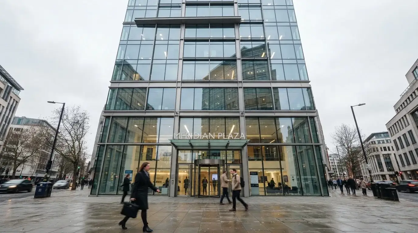 Blick auf eine moderne Bürofassade mit Glasfront von der Strasse aus, Passanten unscharf im Vordergrund.